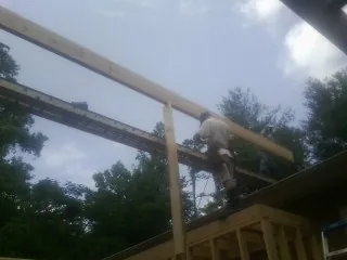Carpenter setting a ridge beam over a new addition frame — Ice Dam Removal by Roofing Brothers in Millerstown