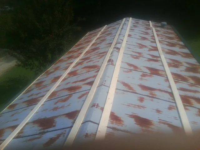 Rusted metal roof panels with new wood purlins before replacement — Storm Damage Roof Repair in Millerstown by Roofing Brothers