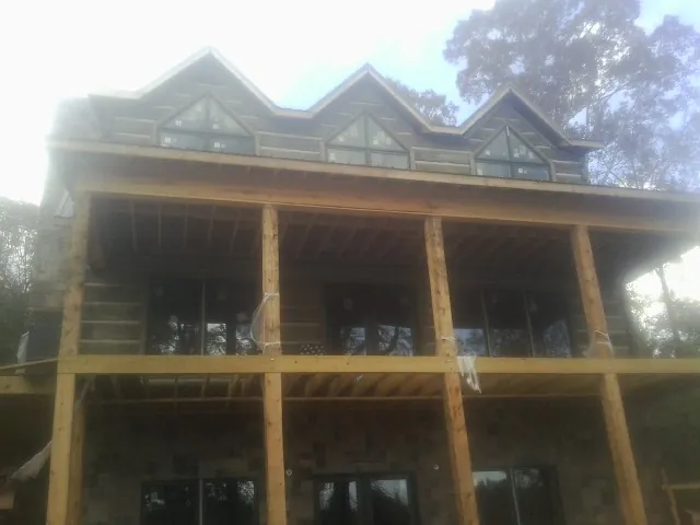 Dormers and porch framing on a large log home under construction — Roof Coating work by our crew in Millerstown