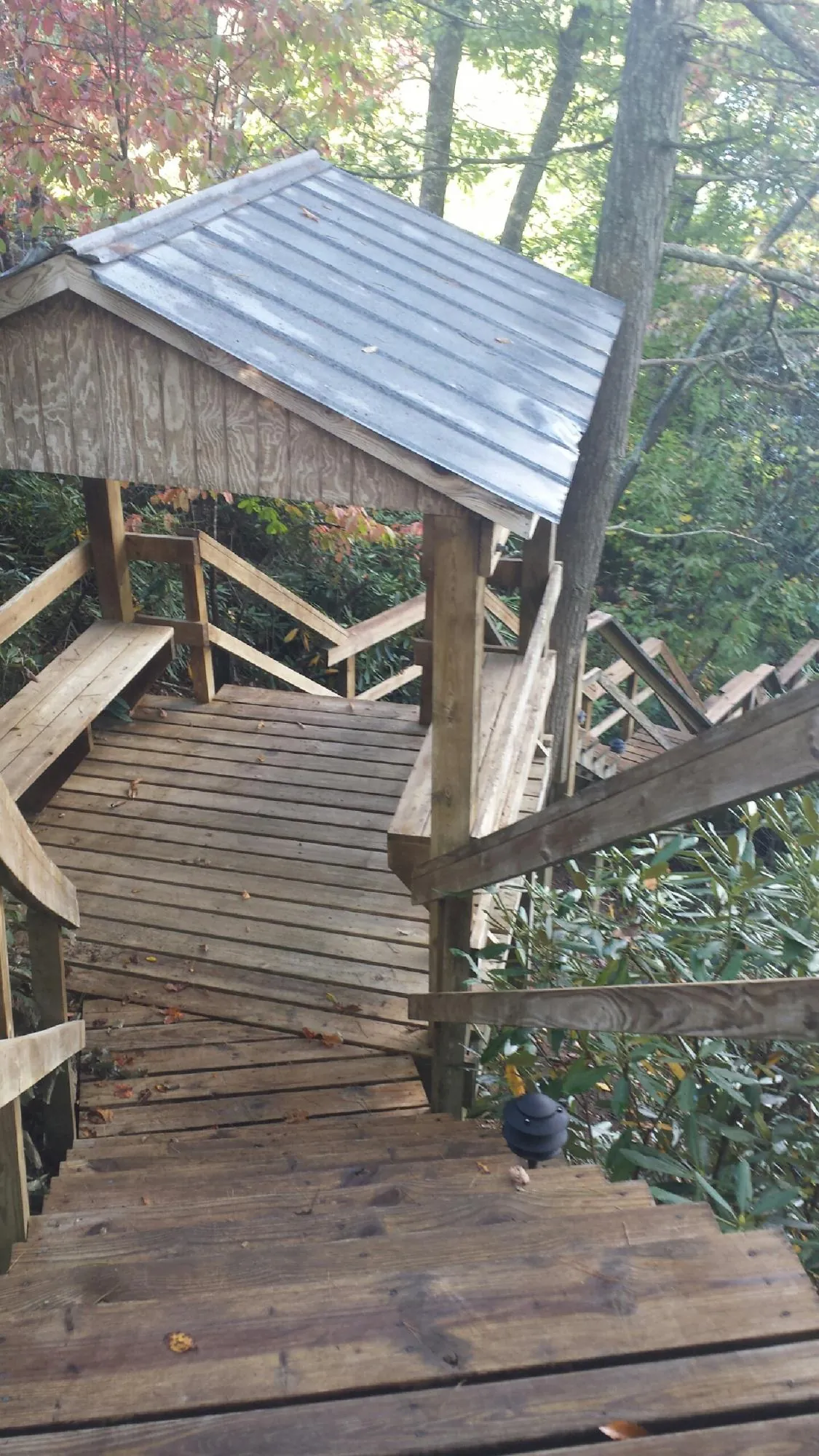 Metal roofed shelter over wooden steps on a wooded walkway — Skylight Repair & Installation work by our crew in Millerstown