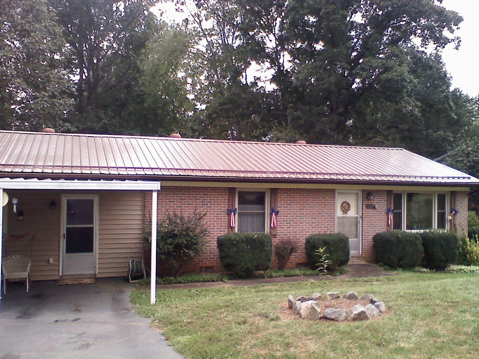 Bronze metal roof and carport on a brick ranch home — Roof Repair work by our crew in Millerstown